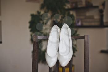 White shoes on the back of the chair.