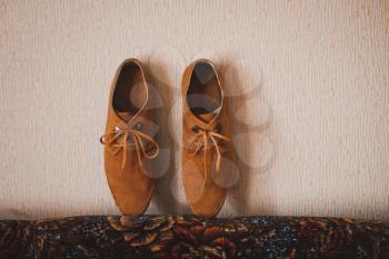 Asseksuara of the groom before wedding: boots and a box with wedding rings.