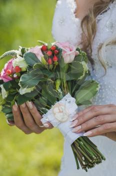 Bouquet of white and pink roses in hands of bride.