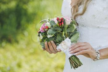 Bouquet of white and pink roses in hands of bride.