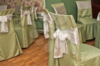 Chairs decorated for a holiday bows and with the dressed covers.