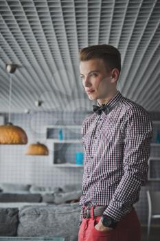 Portrait of a boy in a striped shirt and a bow tie in the cafe.