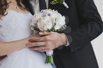 A bouquet of flowers in the hands of the bride.