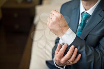 Hands of the young man clasping a shirt.