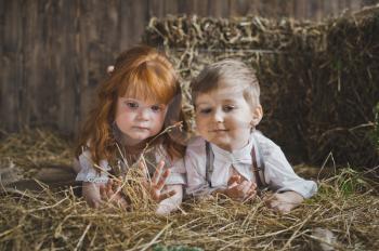 Portrait of children lying in a haystack.