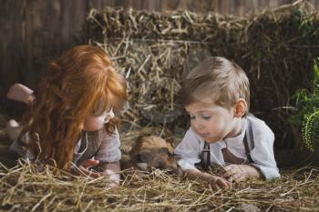 Boy and girl lie and play in the haystack.