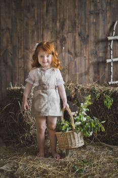 Portrait of a redhead little girl with a basket.