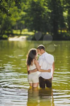 Portrait of a young couple on the shores of green lake.
