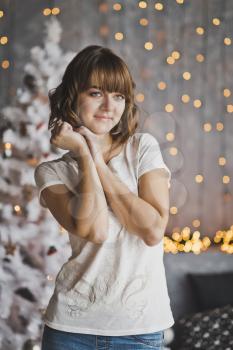 Portrait of a dreaming girl in the background of the Christmas lights.