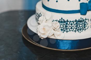 Cake with dark blue patterns and roses.