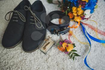 Bright multicolored bouquet and mens accessories on white background.