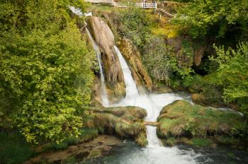 Bubbling stream waterfall falls from a great height.