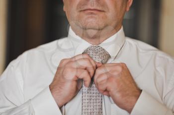 Strong business man tying a tie knot.