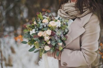 Beautiful winter bouquet of flowers in the hands of the bride.