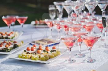 Beautiful holiday table with snacks and a pyramid of glasses.