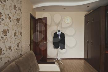 Mens suit on a hanger in the middle of the room.