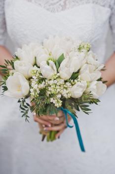 Bouquet of white roses in female hands.
