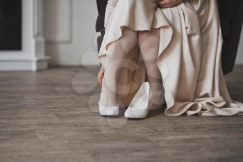 Feet of a girl wearing white shoes.