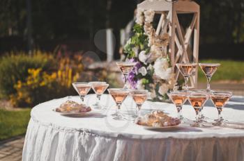 Table for guests with pyramids of champagne glasses.