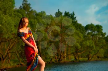 girl in colorful dress at the sea. hippies at sunset enjoying a summer evening. Lifestyle