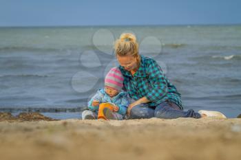 Mother And Daughter On Holiday Standing On Winter Beach