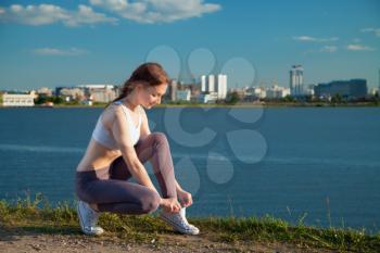 Young sportive woman getting ready to start running workout - Athlete running outdoors at sunset . Attractive girl making spor