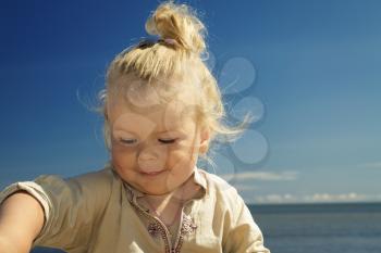 portrait of a little girl on the beach in the summer .