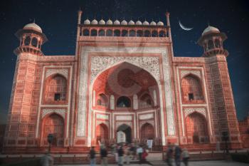 gate through which the Taj Mahal . At night, under the stars and moon