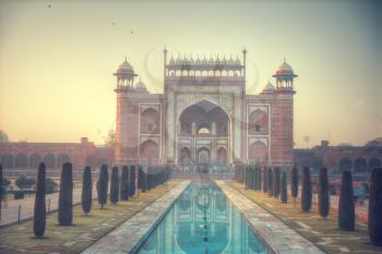 gate through which the Taj Mahal visitors in a park that surrounds the mausoleum