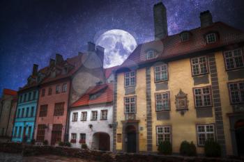 At night the moon and stars shine. old houses on Riga street. Latvia. Europe