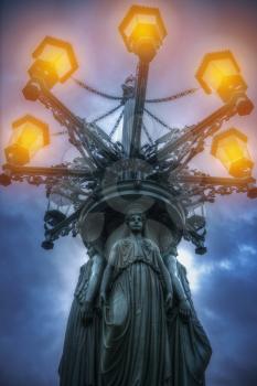 lantern with caryatids shines at night. Prague