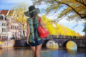 girl with a red bag walks around Amsterdam.