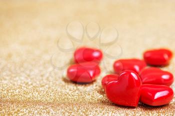 red hearts on a table, red hearts on golden background