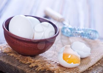 raw eggs in bowl and on a table