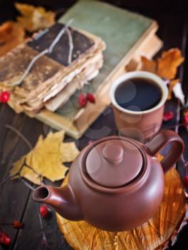 fresh tea in teapot on wooden board and on a table
