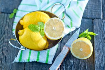 lemons in metal bowl and on a table