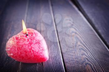 One red candle on the wooden table