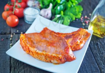 raw meat in marinad and on wooden board