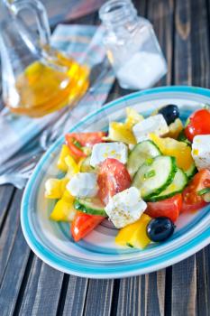 fresh greek salad on plate and on a table