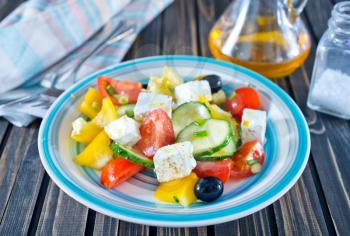 fresh greek salad on plate and on a table