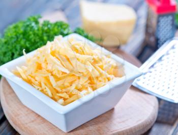 grated cheese in bowl and on a table