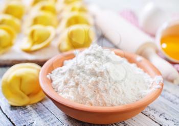 flour and raw pelmeni on a table