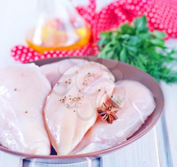 raw chicken fillet on plate and on a table