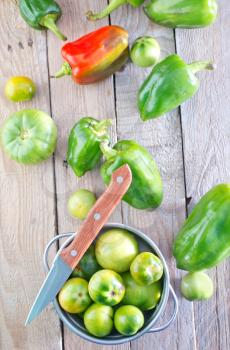green tomato and pepper on the wooden table