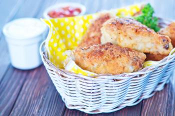 fried chicken wings in basket and on a table