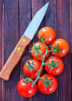 tomato cherry and knife on tha wooden table