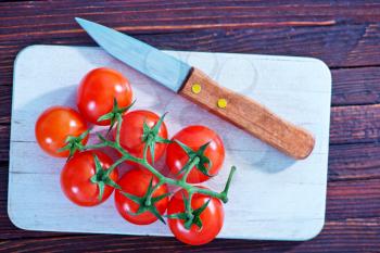 tomato cherry and knife on tha wooden table