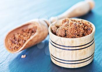 brown sugar in wooden spoon and on a table