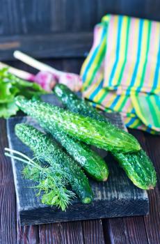 fresh cucumbers on board and on a table