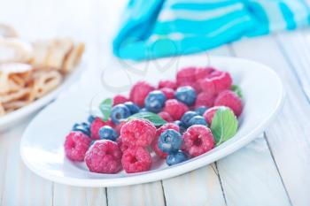 fresh berries on plate and on a table